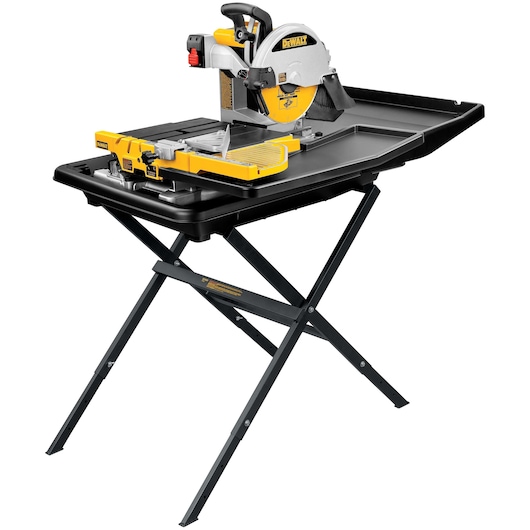 A DEWALT tile saw with a yellow and silver design is mounted on a black folding stand. The saw has a water tray and adjustable guide for precise cutting.