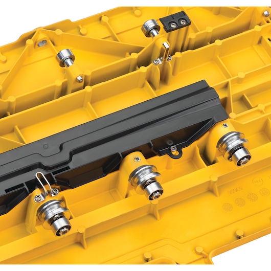 Close-up of a yellow DEWALT tool component, featuring metal rollers and a black plastic part attached to the structure.