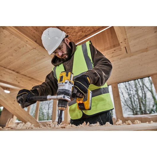 DEWALT DCD1007NT, DCZ607X2-XE drill used in construction setting, person in safety gear working with wood.