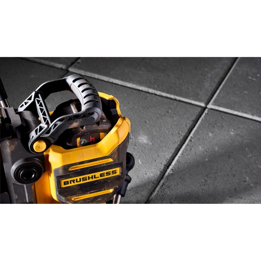 Close-up of a DEWALT brushless cordless tool on a tiled floor, showing handle and branding.