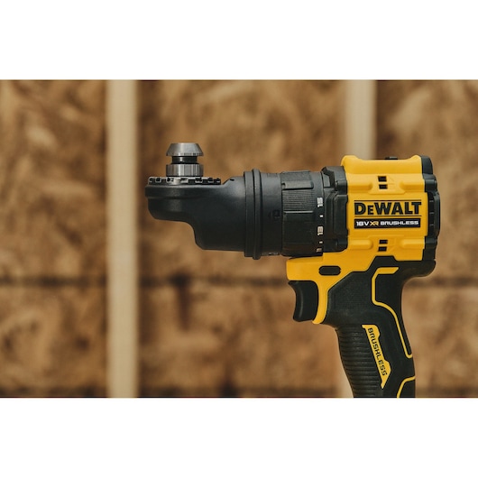 Close-up of a DEWALT 18V XR brushless cordless drill, showing the side view of the tool with a yellow and black handle against a wooden background.