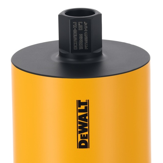 Close-up of a DEWALT yellow cylindrical core drill accessory with black top and branded logo.