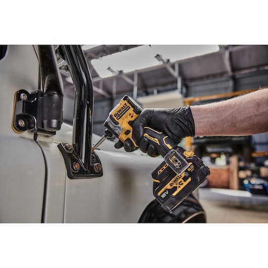 DEWALT tool in use on vehicle; SKUs DCF850N, DCZ2050P2T-XE, DCZ401P3-XE visible. Person wears black glove.