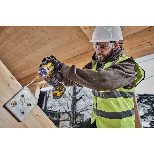 DEWALT DCZ507T2-XE, DCZ407P1T1-XE, DCZ607X2-XE, DCZ503X2-XE, DCF860N in use at construction site. Worker drilling wood.