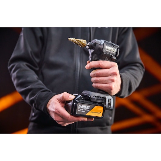 DEWALT drill in hand, battery close-up, SKUs DCF86MP2T-QW, DCF86MP2T, product category Photography.