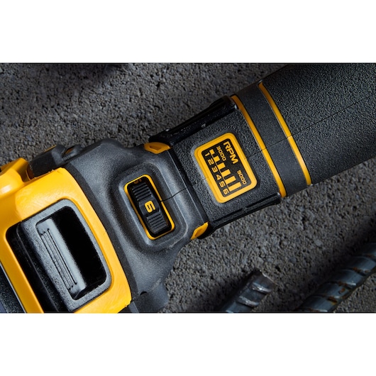 Close-up of DEWALT power tool showing speed adjustment dial and RPM settings on textured surface.