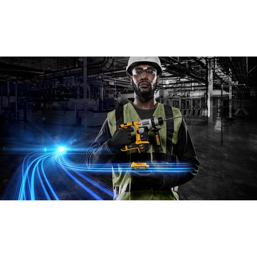A person wearing a hard hat and safety vest holds a DEWALT cordless rotary hammer drill (SKU: DCH172E2T) in an industrial environment, with blue light streaks in the foreground and factory machinery in the background. The person's face is blurred for privacy.