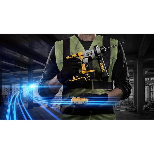 A person wearing a safety vest and gloves holding a DEWALT DCH172E2T cordless hammer drill in a construction site, with blue light trails added for visual effect.