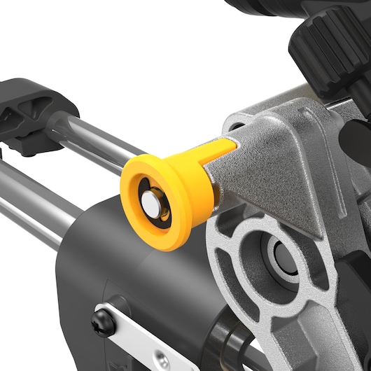 Close-up view of a part on a DEWALT power tool, showing a yellow cylindrical detail attached to silver and black components, with textured metal surfaces and adjustment mechanisms.