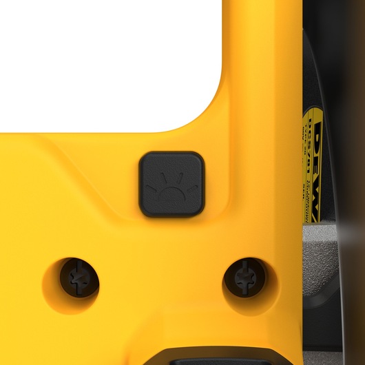Close-up view of a yellow DEWALT power tool featuring a black button with a light bulb symbol, indicating a light function, alongside screw holes and a visible label.