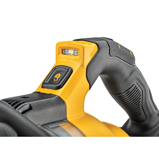 Close-up view of the handle and control switch of a DEWALT power tool, featuring a yellow and black ergonomic design and an integrated LED light.