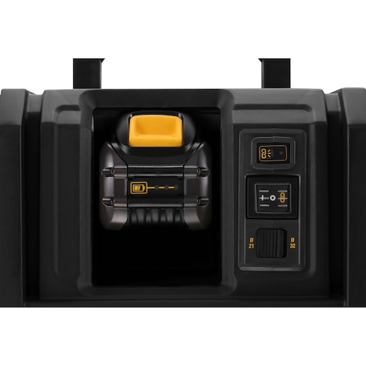 Close-up view of the control panel and battery compartment of a DEWALT power tool, showing battery insertion area and various buttons for operation settings.