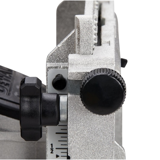 Close-up view of a DEWALT DCW682P2 woodworking tool focusing on adjustment knobs and a measurement scale.