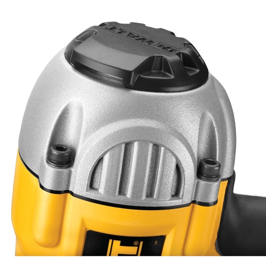 Close-up view of the top section of a DEWALT power tool, featuring a metallic silver and yellow body with a black cap.