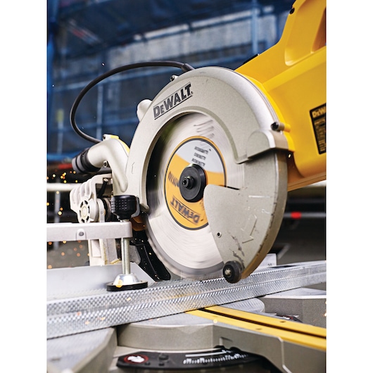 DEWALT circular saw cutting metal in workshop, close-up showing blade and sparks.