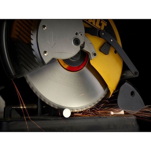 Close-up of a DEWALT circular saw cutting through metal, with sparks visible around the blade.