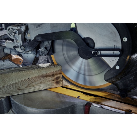 Close-up view of a circular saw cutting through a wooden plank, with clear motion blur on the spinning blade.