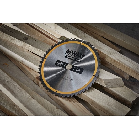 DEWALT circular saw blade with 48 teeth and a diameter of 305 mm, placed on top of several wooden planks.