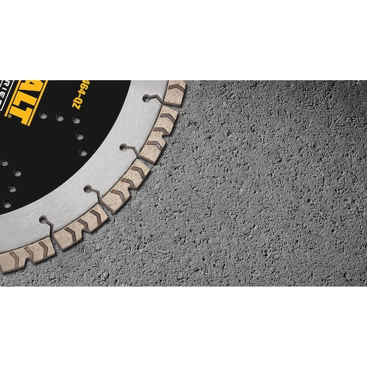 Close-up view of a DEWALT segmented diamond saw blade, partially visible, laying on a rough concrete surface.