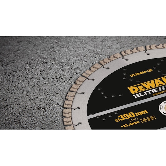 Close-up of a DEWALT Elite Series segmented circular saw blade, partially visible on a rough concrete surface. The blade displays product information including 350 mm (14 inch) diameter and model number DT20464.