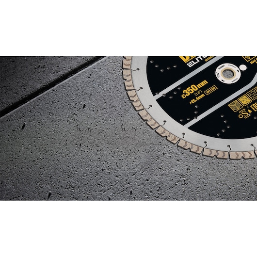 Close-up of a DEWALT diamond cutting disc, partially shown on a concrete surface. The disc is labeled with measurements and specifications.