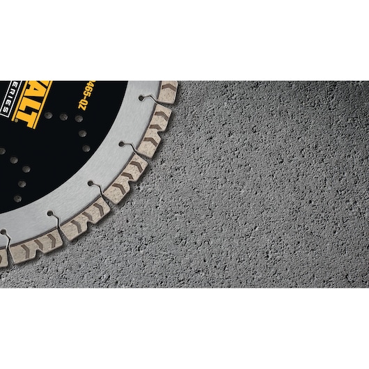 Close-up of a DEWALT segmented diamond saw blade, partially visible, resting on a rough concrete surface.