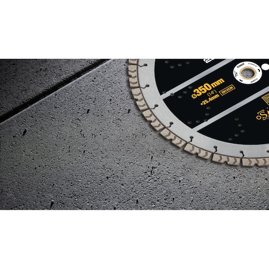 Close-up view of a DEWALT segmented diamond saw blade, partially visible, placed on a concrete surface.