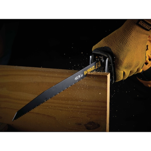 DEWALT saw blade cutting wood, used with gloved hand. Sawdust is visible during action.