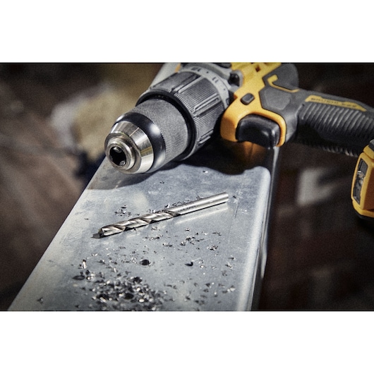 DEWALT drill and drill bit on metal surface with metal shavings, ready for use.