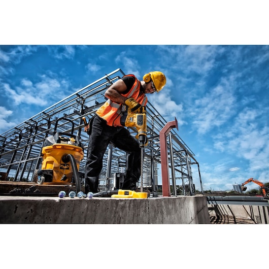 DEWALT DT60820, DT60820-QZ tools in use on construction site, worker with drill wearing safety gear, photography category.