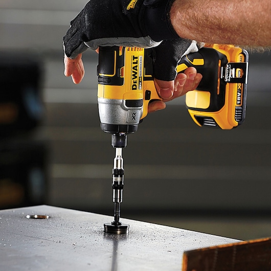 DEWALT drill in use with DT70578T, DT70578T-QZ SKUs, drilling metal surface. Gloved hand operating tool.