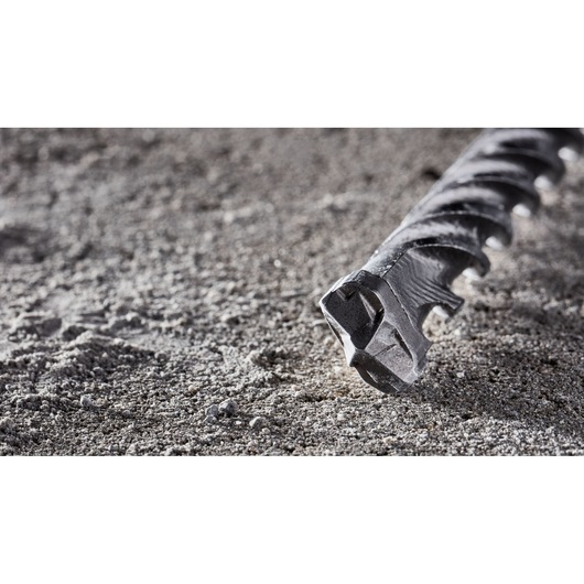 Close-up of a DEWALT DT8917 masonry drill bit resting on rough concrete surface.