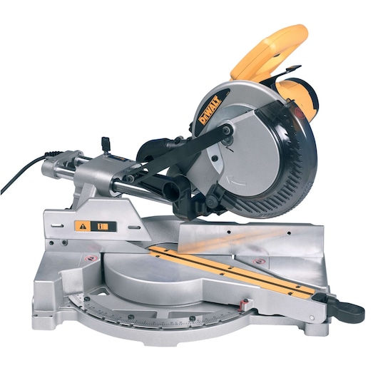A DEWALT DW712 sliding compound miter saw with a silver and yellow design. The saw is plugged in and positioned on a flat surface, with measurement markings visible on the base.