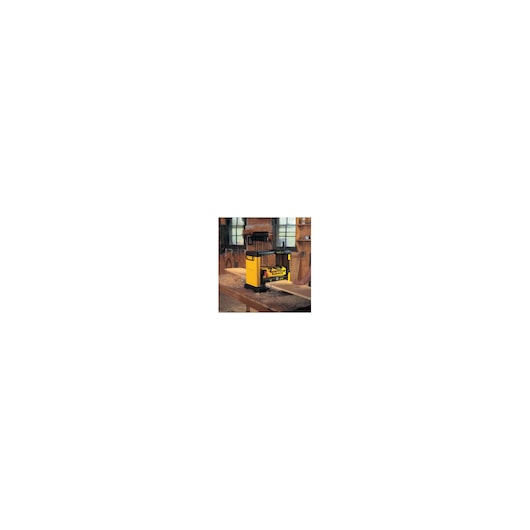 A DEWALT DW733 woodworking planer in a workshop setting, placed on a workbench with wood pieces around.