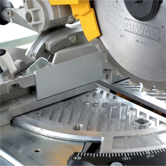 Close-up view of a DEWALT DW743N miter saw with a visible circular blade and metal base, showing detailed parts and mechanisms.