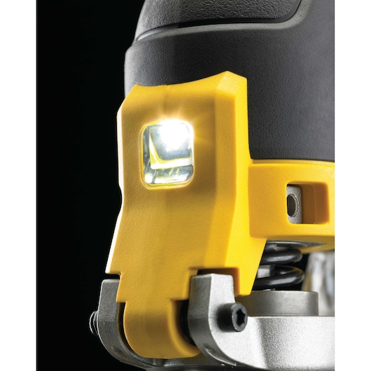 Close-up of a DEWALT power tool with a bright LED work light, showing yellow and black components, metal parts, and detailed texture.