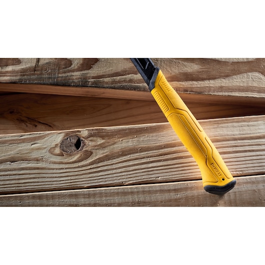 Close-up of a DEWALT yellow-handled hammer resting on wooden planks.