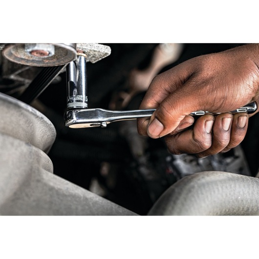 Hand using a DEWALT ratchet wrench to tighten a fastener in an engine compartment.