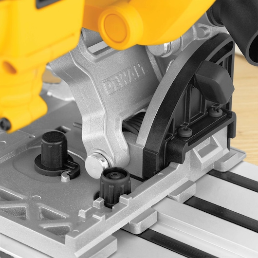 Close-up view of a DEWALT plunge saw, showing the detail of the metal base, adjustment knobs, and track alignment mechanism.