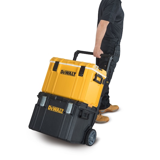 Person pulling a yellow and black DEWALT rolling tool box with handle and wheels on a white background.