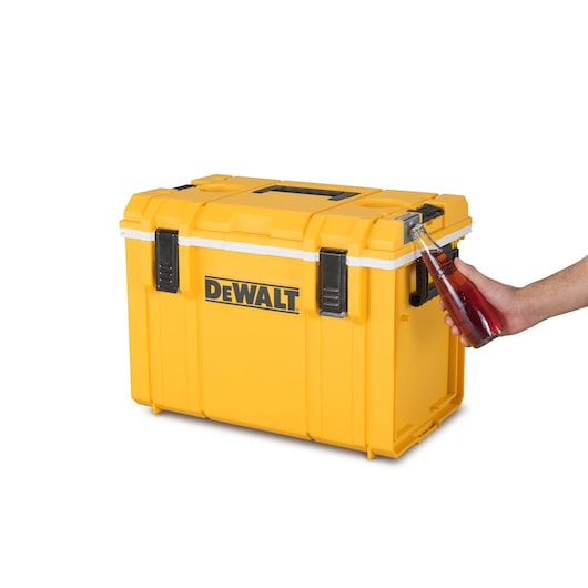 Yellow DEWALT cooler box with built-in bottle opener, showing a hand opening a bottle.
