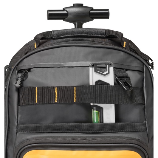Close-up of a DEWALT black and yellow rolling tool bag showing the telescopic handle, a front pocket, and a spirit level stored behind a black strap.