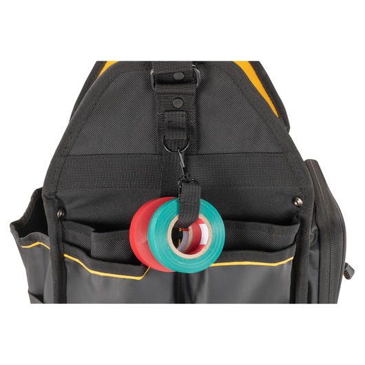 Close-up view of a DEWALT black tool bag with two rolls of tape, one red and one green, attached to a loop on the front.