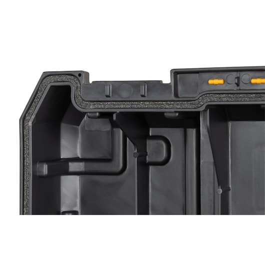 Close-up of the inside corner of a black DEWALT tool case with molded compartments and foam lining.