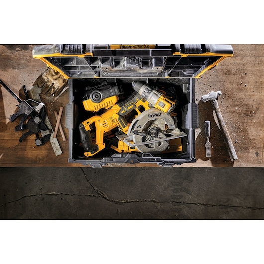 A DEWALT ToughSystem 2.0 toolbox is open on a wooden workbench, showing power tools including a drill and circular saw