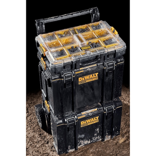 DEWALT ToughSystem 2.0 stack of toolboxes on wheels, with organizer compartments, shown on muddy ground.