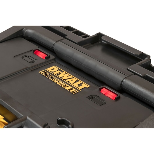 Close-up view of a DEWALT ToughSystem 2.0 black tool storage box with a large central handle, red latches, and DEWALT branding in gold letters.