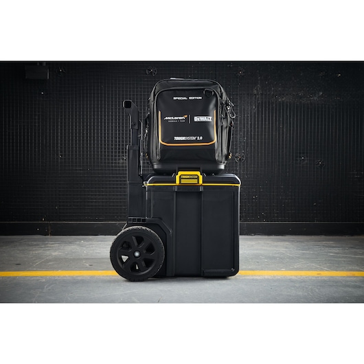 DEWALT ToughSystem 2.0 tool storage, McLaren edition, with backpack and large wheeled case on industrial floor.