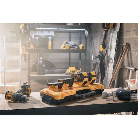 DEWALT photography of DCB548, DCB183, DCB104, DCB184 batteries and tools on a workshop table.