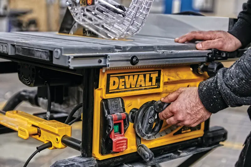 Photo of DEWALT table saw, SKUs DWE7492SET, DWE7492, DWE7492-QS, close-up of controls in workshop setting.